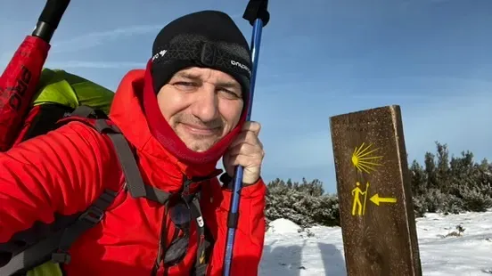 Diego en el Camino en invierno, junto a una señal amarilla